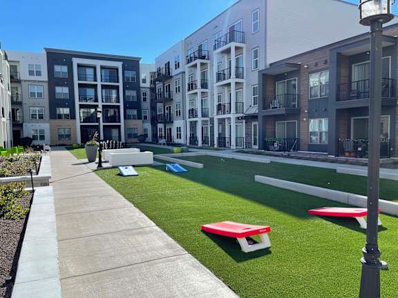 A grassy area with benches in front of apartment buildings at 42 Hundred On The Lake, St Francis, Wisconsin, 53235