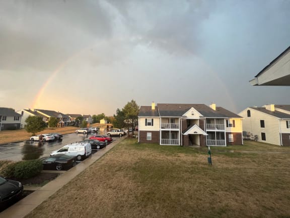 a rainbow in the sky over a neighborhood of houses