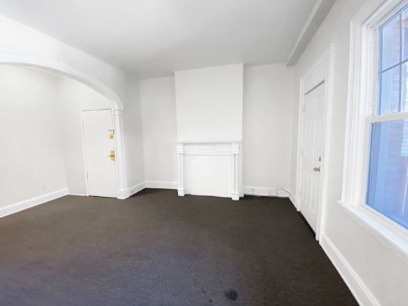 A room with white walls and a window.