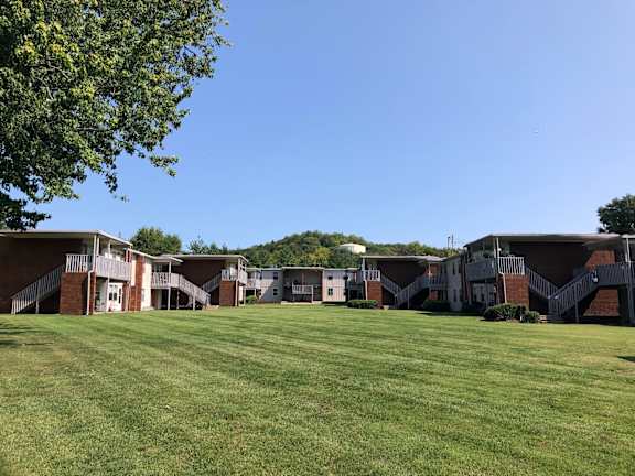 a row of apartment homes and freshly cut lawn pictured against a clear blue sky