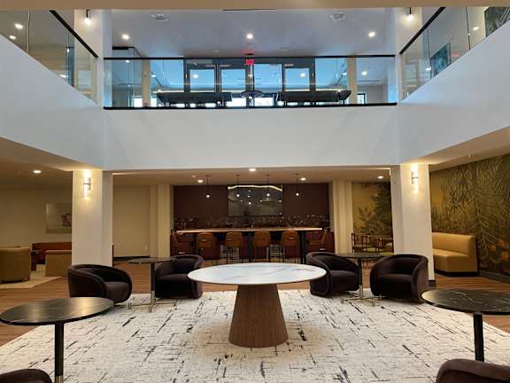 A large, open-plan office space with a central table surrounded by chairs.
