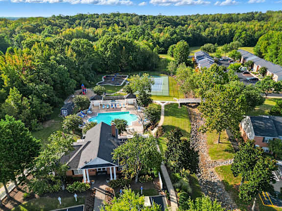 A large swimming pool surrounded by trees and a building.