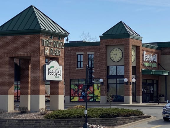 the front of a restaurant with a clock on the building