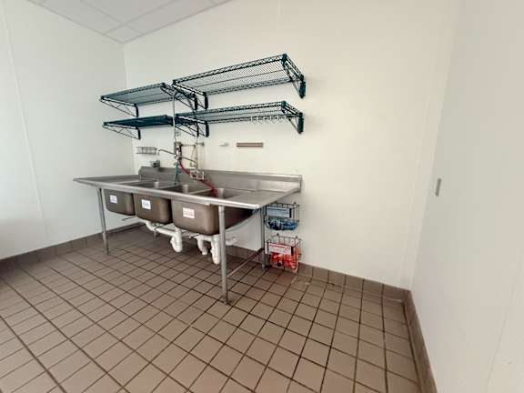 A kitchen with a table and containers on it.