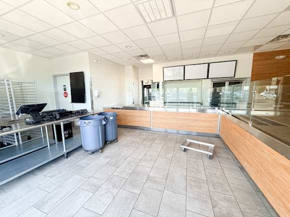 A clean, empty office space with a trolley and two bins.
