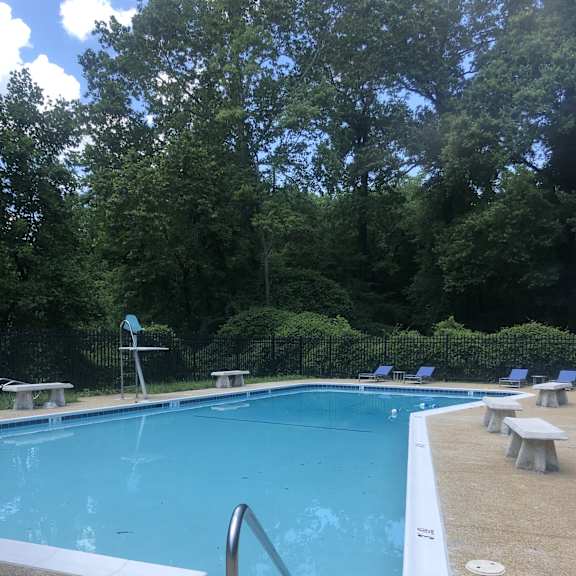 A pool with a diving board and a metal ladder. at New Carrollton Woods, Riverdale, MD