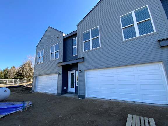 A house with a black door and white garage door.