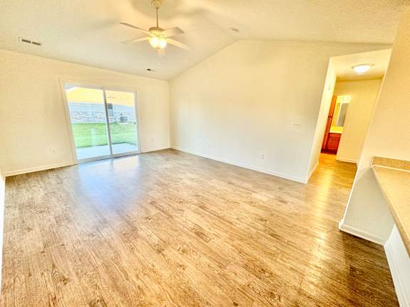 the living room and dining room of an empty house with a ceiling fan at Hawthorne Properties in Lafayette, IN 47905