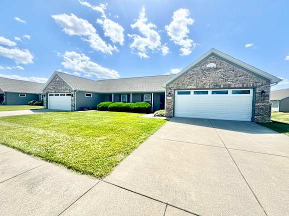 a house with a white garage door and a lawn  at Hawthorne Properties in Lafayette, IN 47905