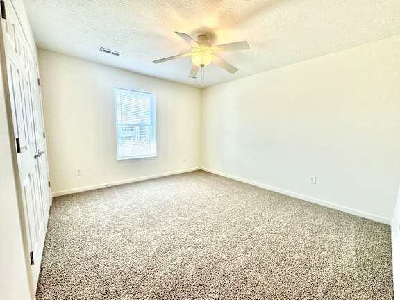 an empty room with carpet and a ceiling fan  at Hawthorne Properties in Lafayette, IN 47905