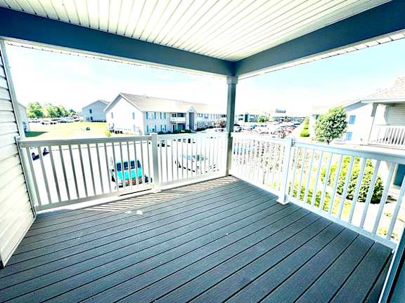 a deck with a view of a parking lot and houses  at Hawthorne Properties in Lafayette, IN 47905