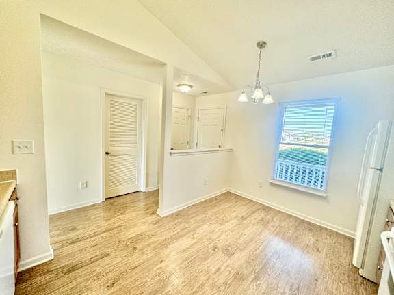 an empty living room with a window and a kitchen  at Hawthorne Properties in Lafayette, IN 47905