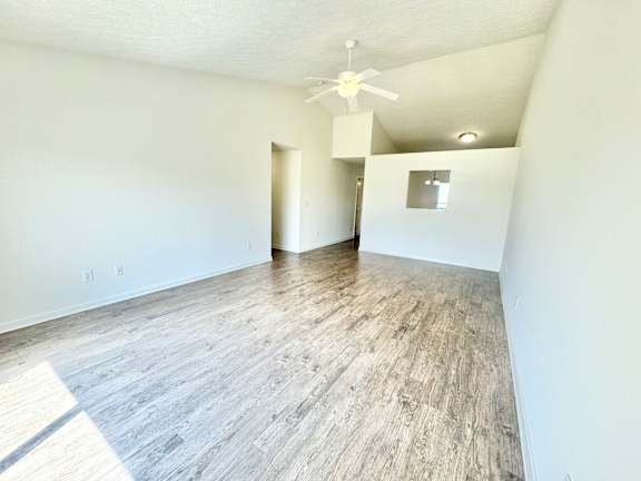 an empty living room with white walls and a ceiling fan  at Hawthorne Properties in Lafayette, IN 47905