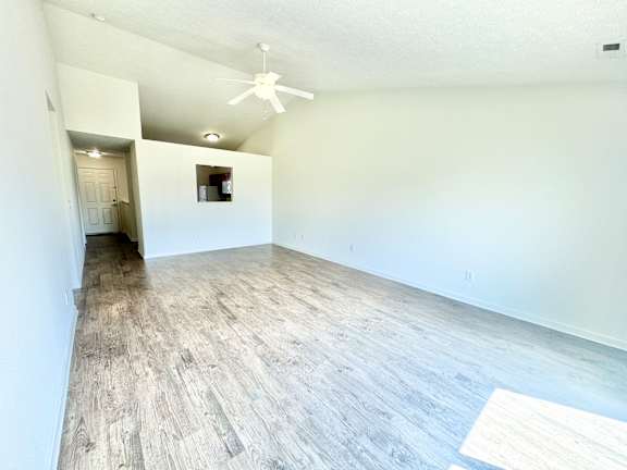 an empty living room with white walls and wood flooring  at Hawthorne Properties in Lafayette, IN 47905