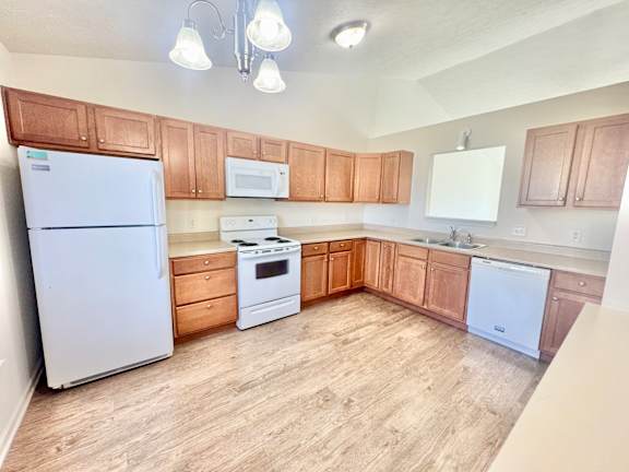 an empty kitchen with white appliances and wooden cabinets  at Hawthorne Properties in Lafayette, IN 47905
