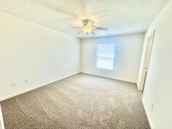 an empty room with a ceiling fan and a window  at Hawthorne Properties in Lafayette, IN 47905