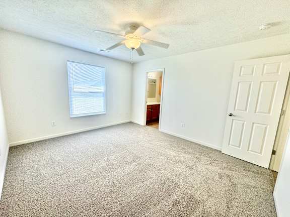 an empty living room with a ceiling fan and a window  at Hawthorne Properties in Lafayette, IN 47905