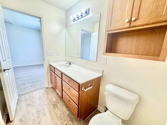 a bathroom with a toilet and a sink and a mirror  at Hawthorne Properties in Lafayette, IN 47905