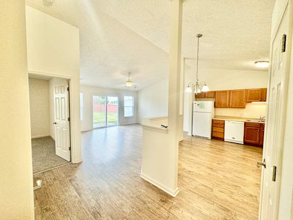 an empty living room and kitchen with a hard wood floor at Hawthorne Properties in Lafayette, IN 47905