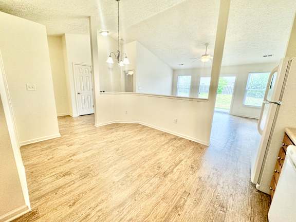 an empty kitchen and living room with a wood floor at Hawthorne Properties in Lafayette, IN 47905