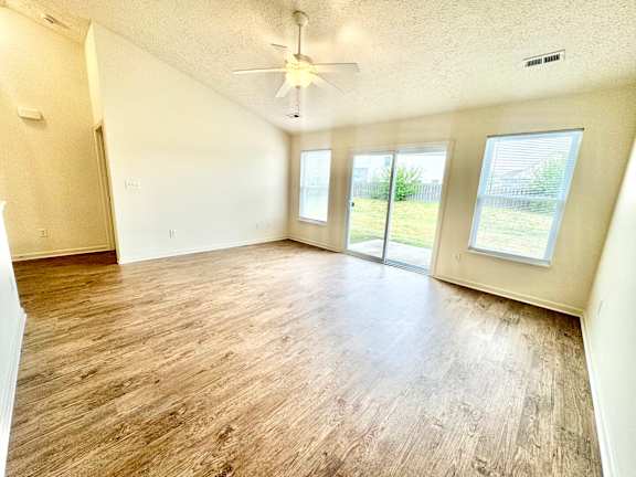 an empty living room with wood floors and a ceiling fan at Hawthorne Properties in Lafayette, IN 47905