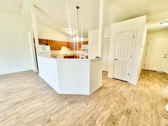 an open kitchen and living room with wood flooring at Hawthorne Properties in Lafayette, IN 47905