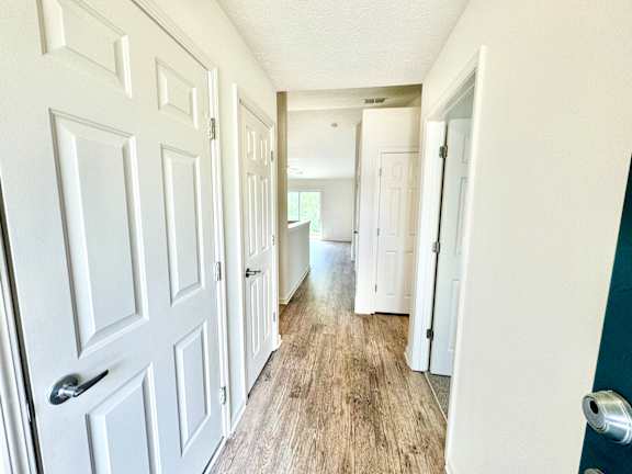 the hallway of a home with white doors and wood floors at Hawthorne Properties in Lafayette, IN 47905