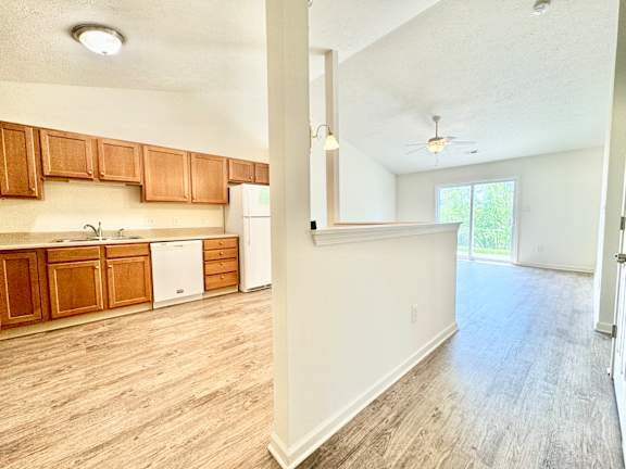 an empty kitchen and living room with wood flooring at Hawthorne Properties in Lafayette, IN 47905