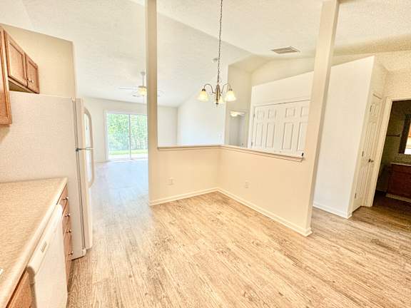 an empty kitchen and living room with a refrigerator at Hawthorne Properties in Lafayette, IN 47905