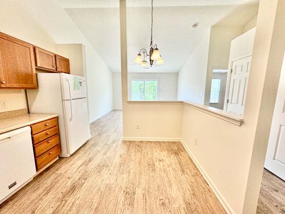 the spacious kitchen and dining room of an apartment with a white refrigerator at Hawthorne Properties in Lafayette, IN 47905