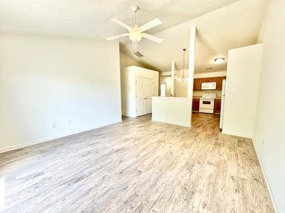 an empty living room with a ceiling fan and a kitchen at Hawthorne Properties in Lafayette, IN 47905
