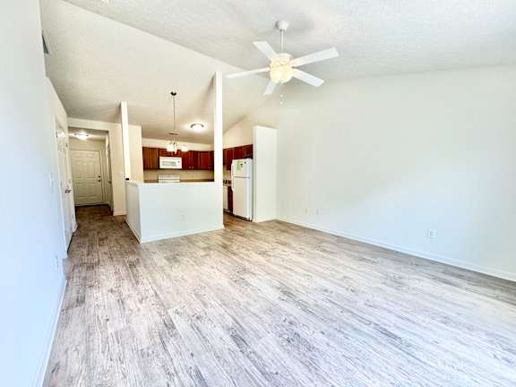 an empty living room and kitchen with a ceiling fan at Hawthorne Properties in Lafayette, IN 47905