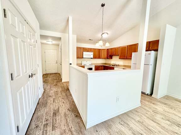 an empty kitchen with a counter top and a refrigerator at Hawthorne Properties in Lafayette, IN 47905
