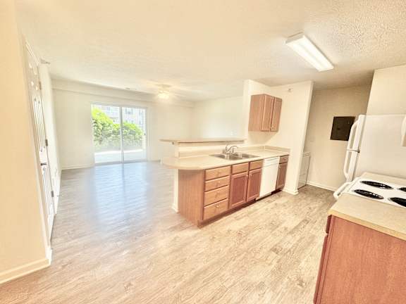 an empty kitchen and living room with wood flooring  at Hawthorne Properties in Lafayette, IN 47905