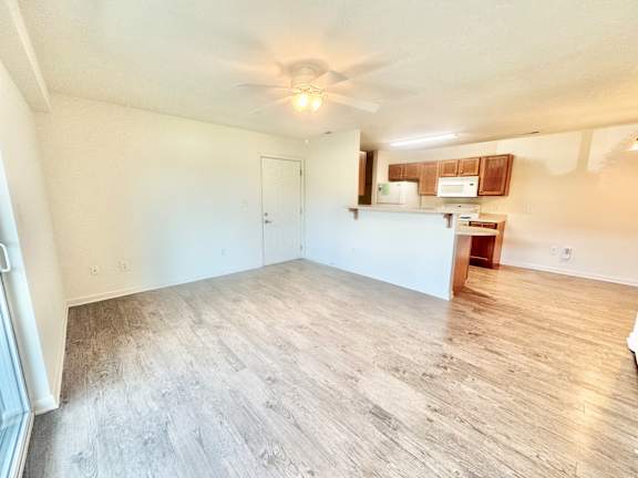 the living room and kitchen of an empty home with wood flooring  at Hawthorne Properties in Lafayette, IN 47905