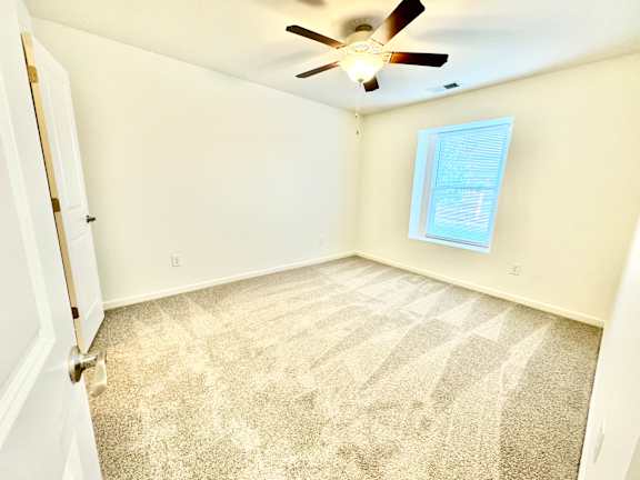 an empty room with carpet and a ceiling fan  at Hawthorne Properties in Lafayette, IN 47905