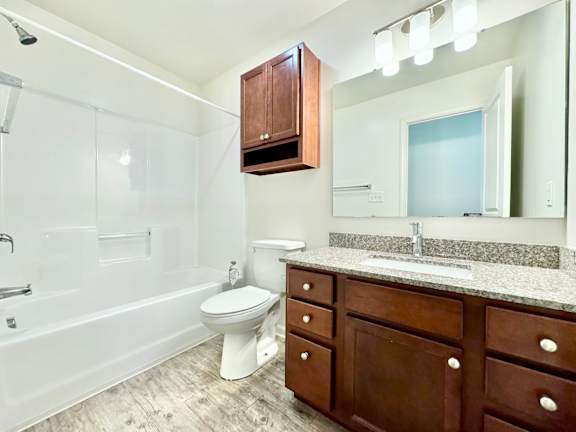 a bathroom with a toilet and a sink and a mirror  at Hawthorne Properties in Lafayette, IN 47905