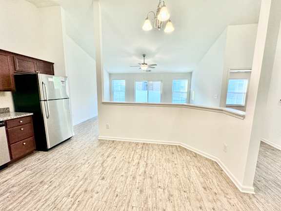 an empty kitchen and living room with a refrigerator and a window  at Hawthorne Properties in Lafayette, IN 47905