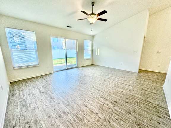 an empty living room with a ceiling fan and a window  at Hawthorne Properties in Lafayette, IN 47905