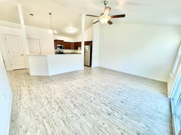 an empty living room and kitchen with a ceiling fan  at Hawthorne Properties in Lafayette, IN 47905