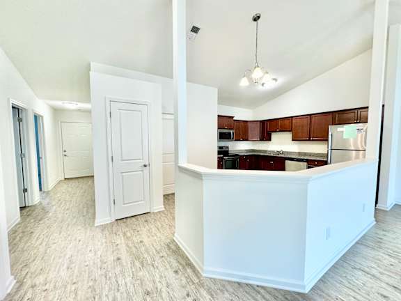 an empty kitchen and living room with a counter top at Hawthorne Properties in Lafayette, IN 47905