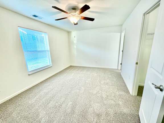 an empty room with a ceiling fan and a window  at Hawthorne Properties in Lafayette, IN 47905