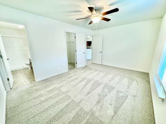 an empty living room with a ceiling fan and white walls at Hawthorne Properties in Lafayette, IN 47905