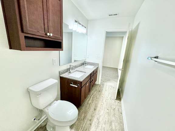 a bathroom with a toilet and a sink and a mirror  at Hawthorne Properties in Lafayette, IN 47905