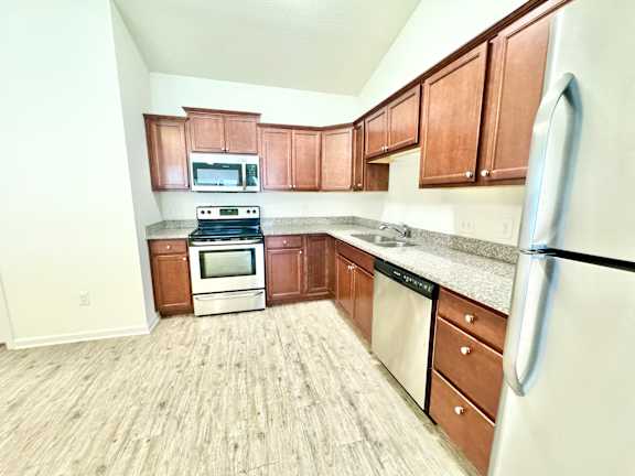 a kitchen with wooden cabinets and stainless steel appliances at Hawthorne Properties in Lafayette, IN 47905