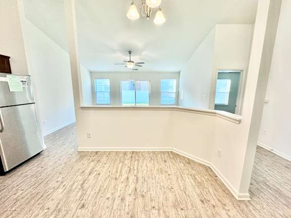 an empty living room with a large window and a kitchen  at Hawthorne Properties in Lafayette, IN 47905