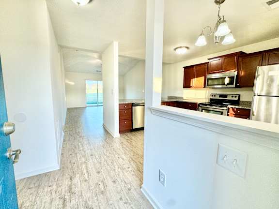 an empty kitchen and living room with wood flooring at Hawthorne Properties in Lafayette, IN 47905
