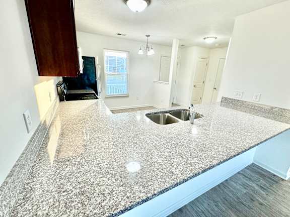 an open kitchen with granite counter tops and a sink at Hawthorne Properties in Lafayette, IN 47905