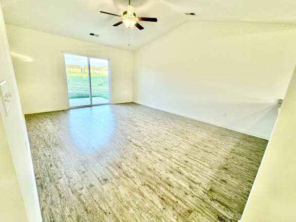 an empty living room with a ceiling fan and a window at Hawthorne Properties in Lafayette, IN 47905