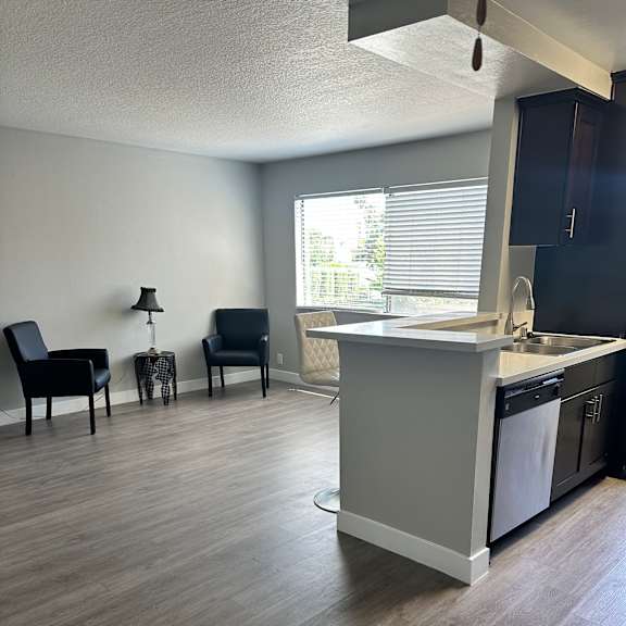 A modern kitchen with a white countertop and a window.